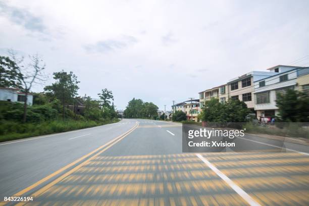 asphalt road with double yellow line in motion blur in the rural - car racing blurred motion bildbanksfoton och bilder