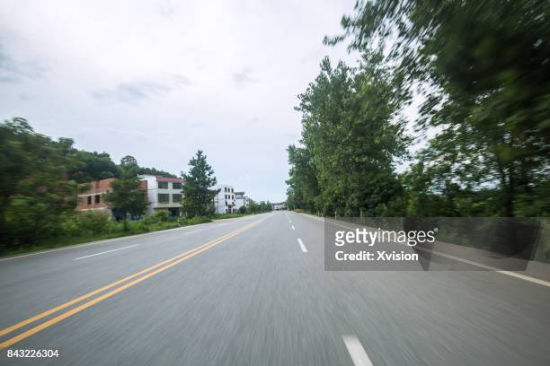 asphalt road with double yellow line in motion blur in the rural - car racing blurred motion bildbanksfoton och bilder
