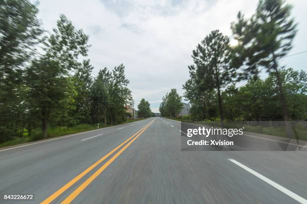 asphalt road with double yellow line in motion blur in the rural - car racing blurred motion bildbanksfoton och bilder