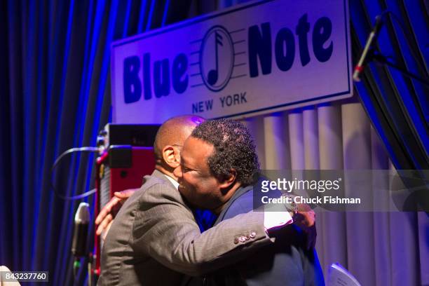 American Jazz musicians Ron Carter and Wallace Roney embrace onstage at the Blue Note nightclub, New York, New York, July 13, 2017.