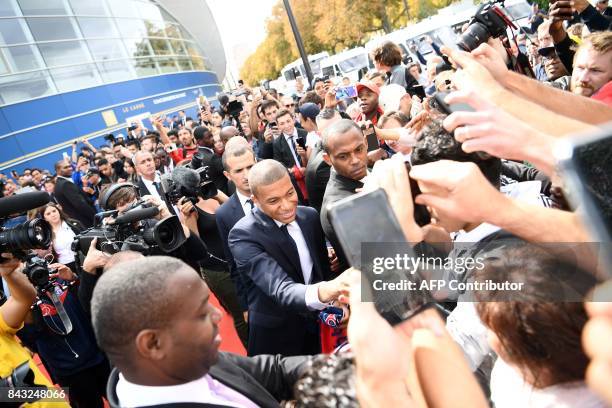 Paris Saint-Germain's new forward Kylian Mbappe signs autographs following his presentation at the Parc des Princes stadium in Paris on September 6,...