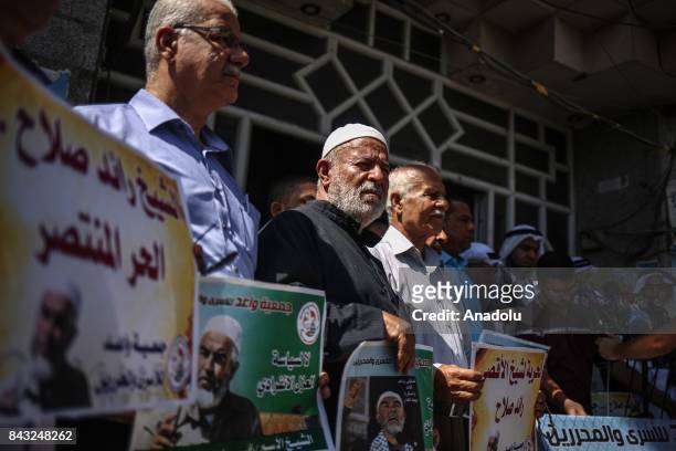 Supporters of 1948 Palestine Islamic Movement Leader Raed Salah who was taken under custody by Israeli forces, hold banners and shout slogans during...