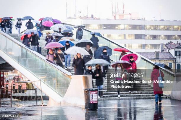 people crossing ponte della costituzione in a rainy day - costituzione photos et images de collection