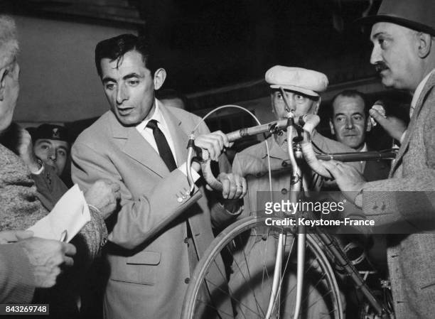 Fausto Coppi avec son vélo prêt pour participer au Tour de Lombardie, à Milan, Italie le 20 octobre 1956.