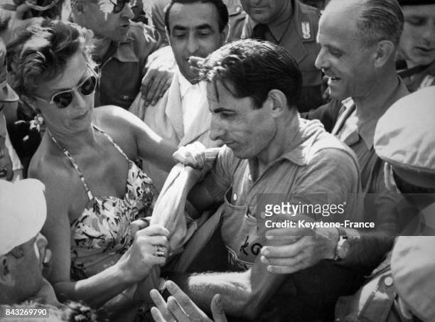 Une belle fan de Fausto Coppi l'aide à vêtir le nouveau maillot après l'tape de Sestrières, Italie en 1952.