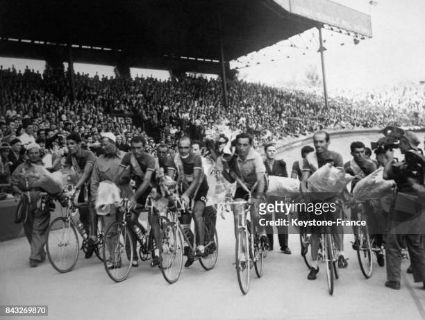 L'arrivée du Tour de France au Parc des Princes, l'équipe italienne fait le tour d'honneur, Fausto Coppi le vainqueur au centre porte un bouquet de...