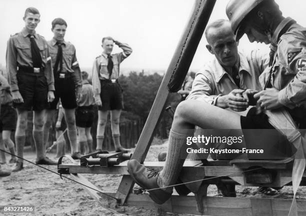 Un instructeur de vol aide un apprenti pilote à boucler sa ceinture avant le décollage de son simulateur dans un camp de formation de pilotes de la...