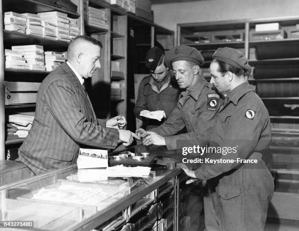 Soldats britanniques discutant avec un commerçant allemand, à Dannenberg, Allemagne, circa 1945.