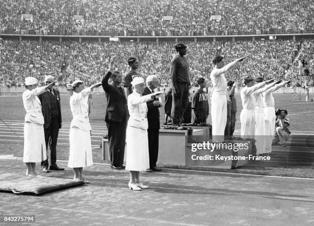 Podium olympique du 4x100 mètres, médailles d'or, équipe des Etats-Unis avec Jesse Owens, argent, équipe d'Italie et bronze, équipe d'Allemagne, à...