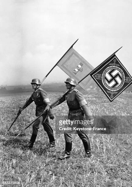 Le drapeau de l'Italie fasciste de Mussolini et celui de l'Allemagne nazie de Hitler sont portés par deux soldats durants une manoeuvre militaire le...