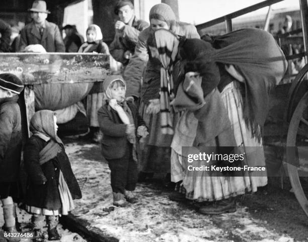 Mère de famille gitane donnant une pipe à fumer à son enfant pour le tenir calme en attendand le train, à Poppendorf, Allemagne, circa 1945.