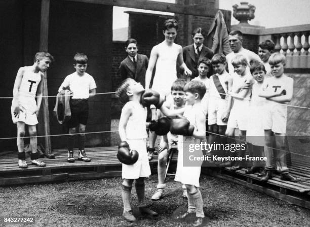 De jeunes garçons s'affrontent à la boxe sous l'oeil de leurs camarades auu Carl Temple Gymnasium, où les mère de familles aisées envoient leurs...