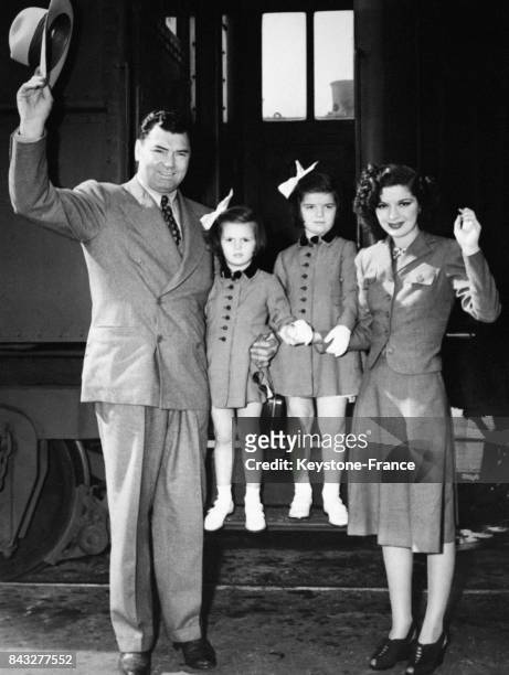 Le boxeur Jack Dempsey, sa femme l'actrice Hannah Williams et leurs deux filles Joan et Barbara saluent à leur descente du train pour assister à...