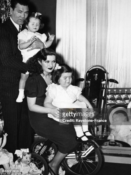 Le boxeur Jack Dempsey avec sa femme, l'actrice Hannah Williams, et ses deux filles Joan et Barbara, à leur domicile pour Noël, circa 1940 aux...
