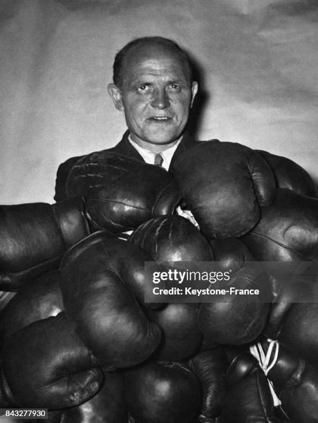 Un homme pose derrière un tas de gants de boxe livrés avant un championnat dans une salle de boxe, à Berlin, Allemagne.