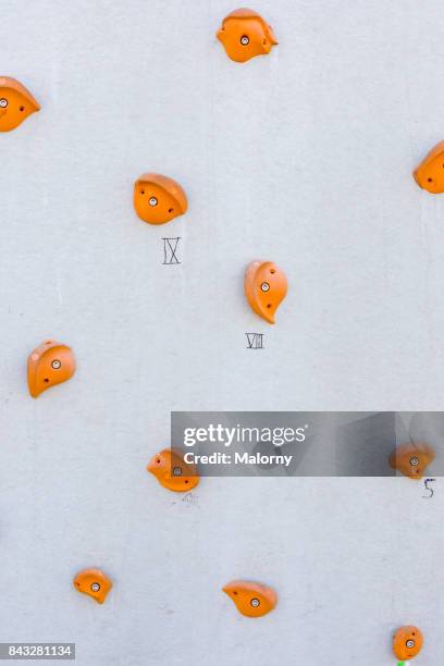 white climbing wall with black and orange grips, bouldering, munich, bavaria, germany - handle stock-fotos und bilder