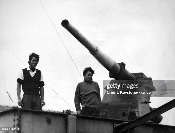 Michael Bates âgé de 15 ans et David Barron de 25 ans photographiés à côté d'un canon antiaérien installé sur le Fort Roughs que la famille Bates...