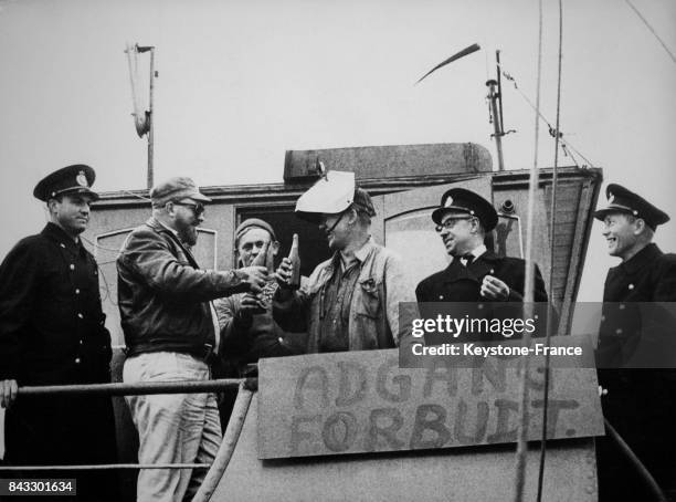 Les policiers danois et les employés de la station de radio pirate 'Radio Mercure' photographiés à bord du bateau qui émettait illégalement au large...