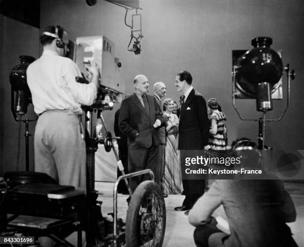 Devant la caméra de télévision de la BBC, le critique musical Ralph Hill discute avec l'acteur Leslie Mitchell, à Londres, Royaume-Uni circa 1940.