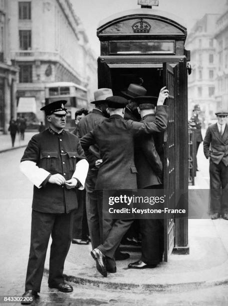 Des agents de la branche routière de Scotland Yard examinent le poste de commande entièrement automatique qui permet de surveiller la circulation sur...