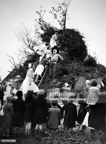 Les enfants regardent les nurses hissant l'effigie de Guy Fawkes au-dessus du feu de joie, au Royaume-Uni le 5 novembre 1927.