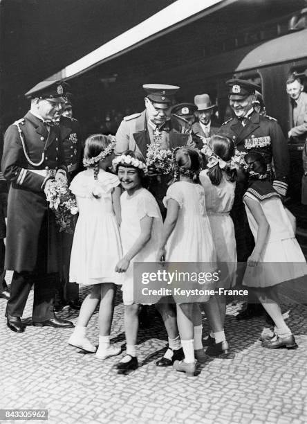 Des petites filles donnent au président du reich Paul von Hindenburg des bouquets de fleurs lors de la parade navale à Kiel, Allemagne, le 21 mai...