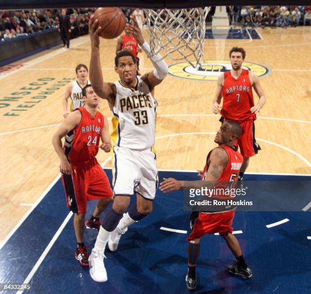 Danny Granger of the Indiana Pacers lays the ball up over Jason Kapono and Will Solomon of the Toronto Raptors at Conseco Fieldhouse on January 16,...