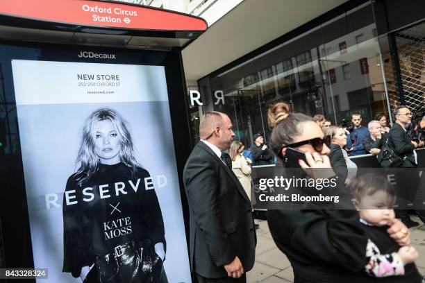 An advertisement featuring British fashion model Kate Moss stands on display on the side of a bus stop outside London's first Reserved store,...