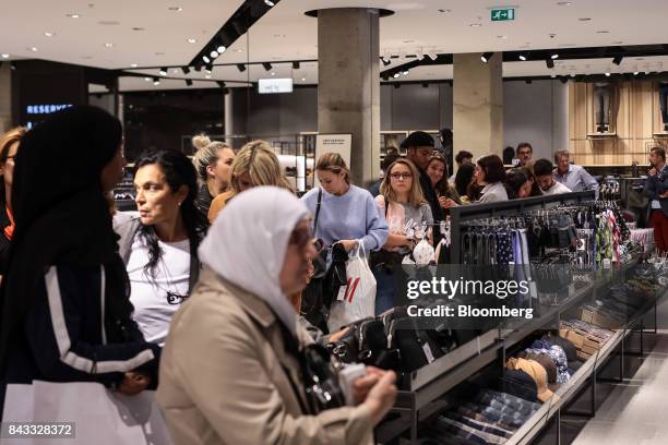 Customers queue to pay for items at London's first Reserved store, operated by LPP SA, during its opening day on Oxford Street in central London,...