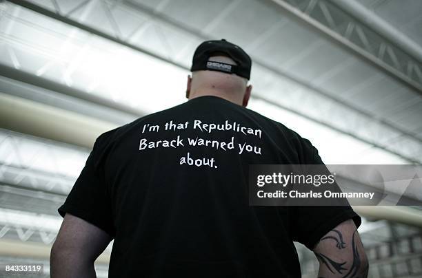 Man, wearing a political T-Shirt listens as Democratic Presidential hopeful Senator Barack Obama speaks to voters at a town hall style meeting...