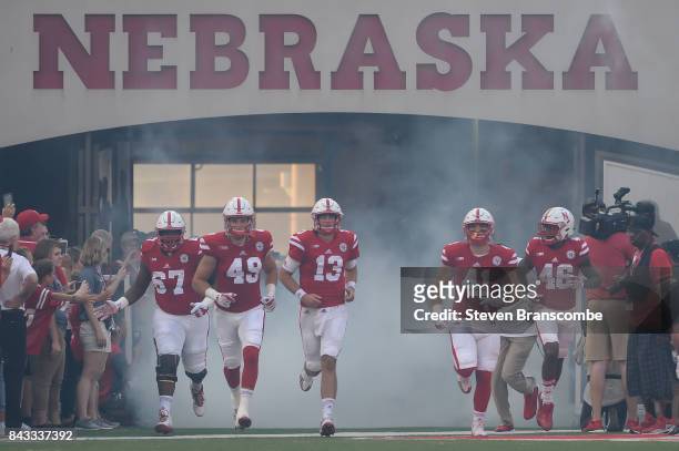 Team co-captains Jerald Foster and Chris Weber and Tanner Lee and Luke McNitt and Josh Kalu of the Nebraska Cornhuskers enter the field before the...