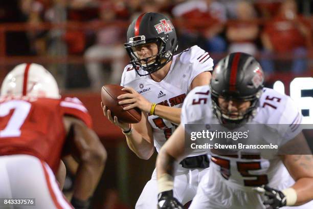 Quarterback Justice Hansen of the Arkansas State Red Wolves takes a snap against the Nebraska Cornhuskers at Memorial Stadium on September 2, 2017 in...