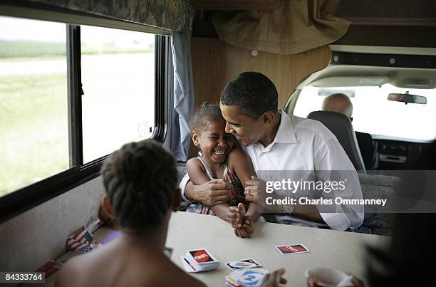 Democratic presidential hopeful U.S. Senator Barack Obama , his wife Michelle and two daughters Sasha and Malia play cards in their RV, July 4, 2007...