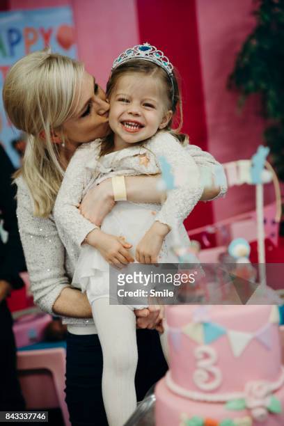 mother kissing birthday girl on cheek - happy birthday crown stock pictures, royalty-free photos & images