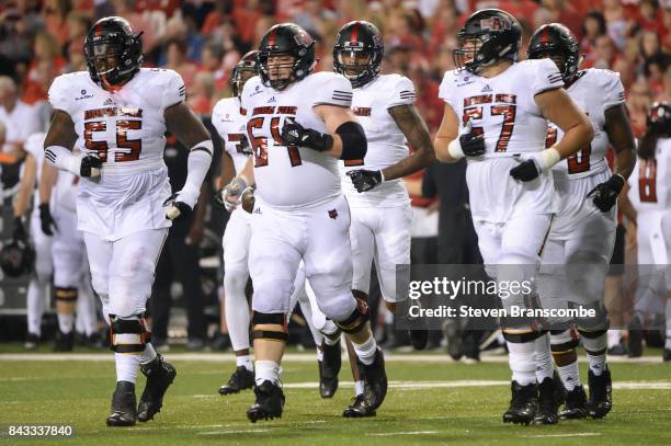 Offensive lineman Jaypee Philbert Jr. #55 and offensive lineman Jacob Still and offensive lineman Troy Elliot of the Arkansas State Red Wolves lead...