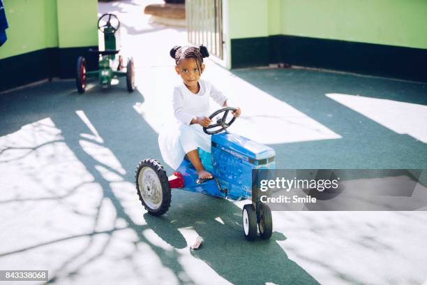 young girl on miniature toy tractor - driving barefoot stock pictures, royalty-free photos & images