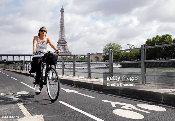 Woman rides his bicycle on the newly created bicycle track along the Seine River near the Eiffel Tower on September 6, 2017 in Paris, France. Mayor...