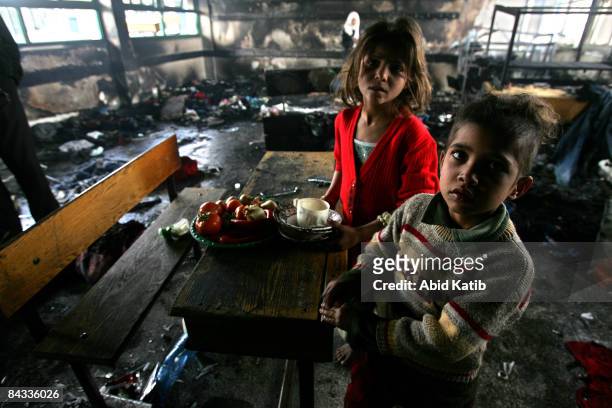 Homeless Palestinian children stand in a burnt classroom at a United Nations school after it was hit by Israeli shelling on January 17, 2009 in Beit...