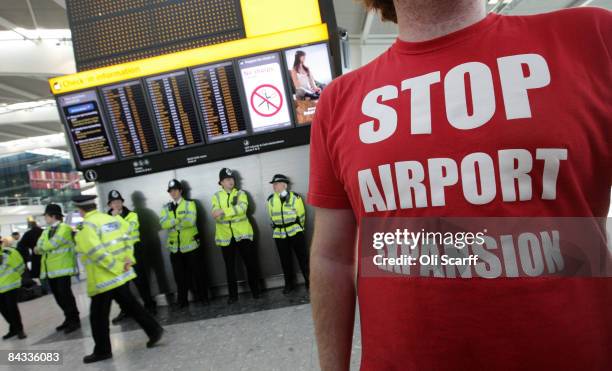 Red T-shirt wearing protesters gather in Heathrow's Terminal 5 to campaign against the Government's plans to build a third runway at the airport on...