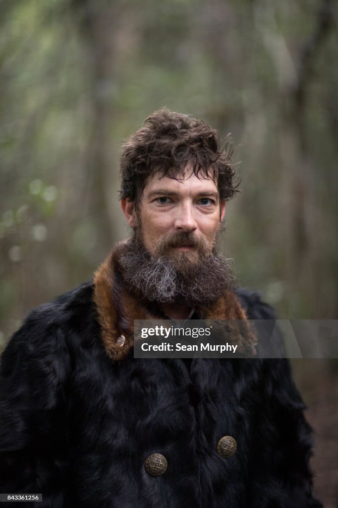 Man in Animal Skin Coat Looking into Camera