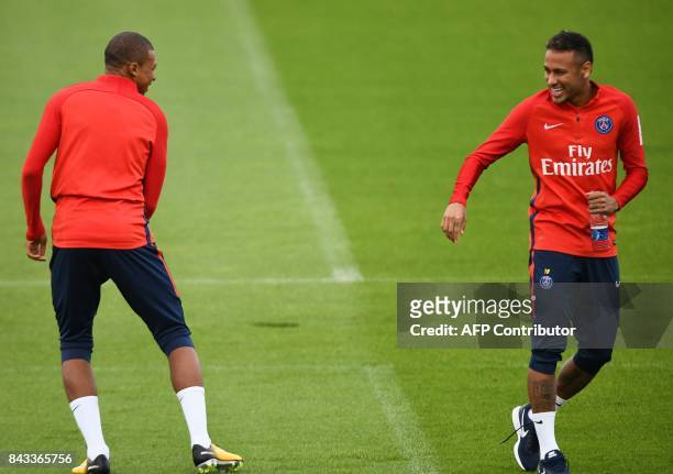 Paris Saint-Germain's French forward Kylian Mbappe and Paris Saint-Germain's Brazilian forward Neymar take part in a training session at the Ooredoo...