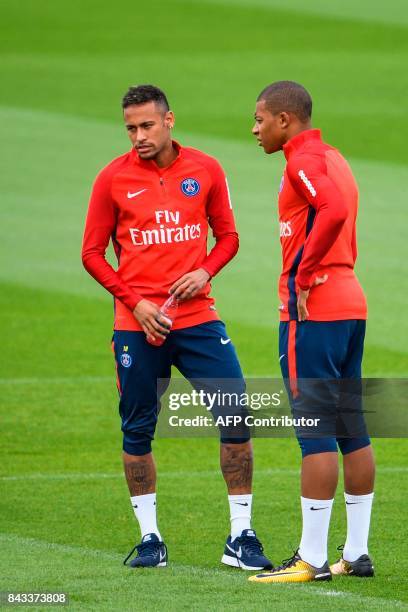 Paris Saint-Germain's French forward Kylian Mbappe and Paris Saint-Germain's Brazilian forward Neymar speak during a training session at the Ooredoo...