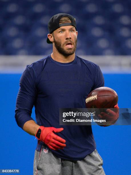 Wide receiver Julian Edelman of the New England Patriots reacts after looking into the lights as he warms up on the field prior to a preseason game...