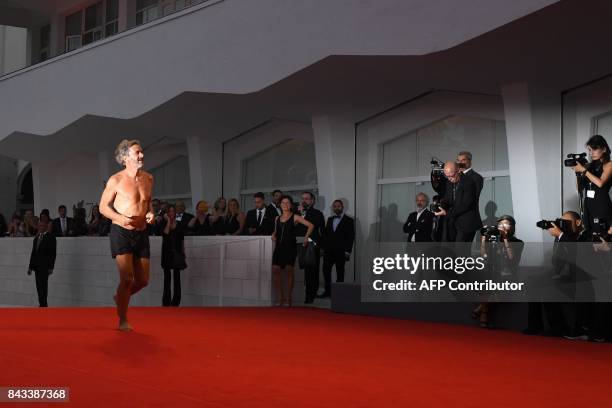 Italian director of the movie "Controfigura", Corrado Sassi, runs in swimsuit on the red carpet prior the premiere of the movie "Ammore E Malavita"...