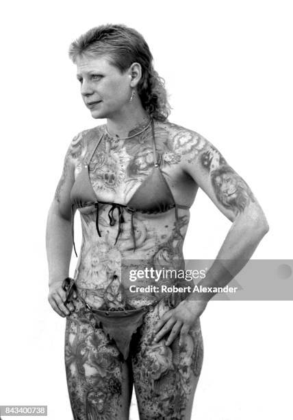 Heavily-tattooed woman poses for photographs in Daytona Beach, Florida, during the city's 1983 Bike Week. The annual motorcycle event and rally has...