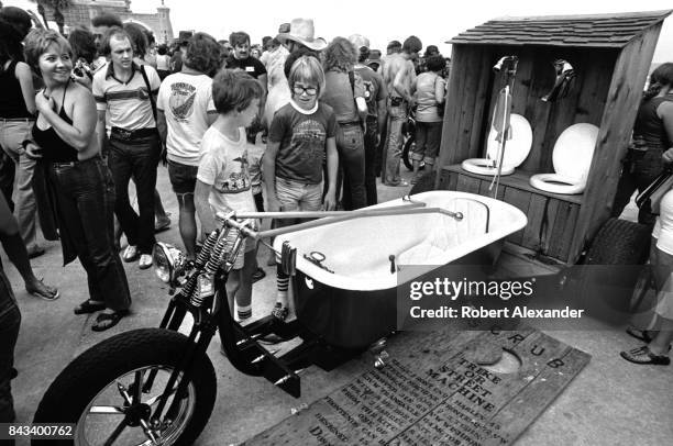 Visitors admire custom motorcycles on display in Daytona Beach, Florida, during the city's 1983 Bike Week. The annual motorcycle event and rally has...