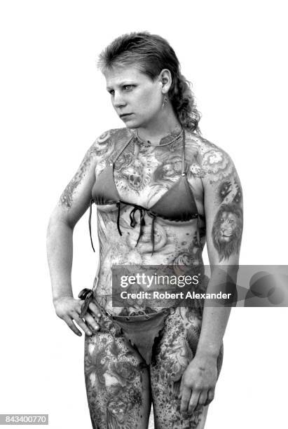 Heavily-tattooed woman poses for photographs in Daytona Beach, Florida, during the city's 1983 Bike Week. The annual motorcycle event and rally has...