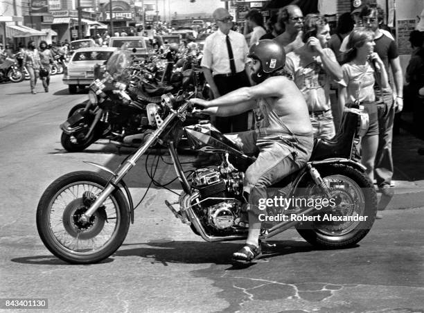 Man rides his motorcycle along a street in Daytona Beach, Florida, during the city's 1983 Bike Week. The annual motorcycle event and rally has...