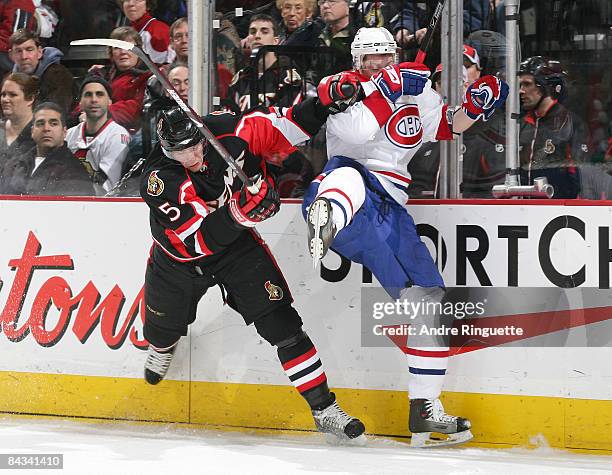 Christoph Schubert of the Ottawa Senators bodychecks Sergei Kostitsyn of the Montreal Canadiens into the boards at Scotiabank Place on January 17,...