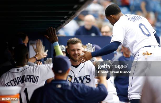 Lucas Duda of the Tampa Bay Rays celebrates in the dugout with teammates after hitting a three-run home run off of pitcher Aaron Slegers of the...